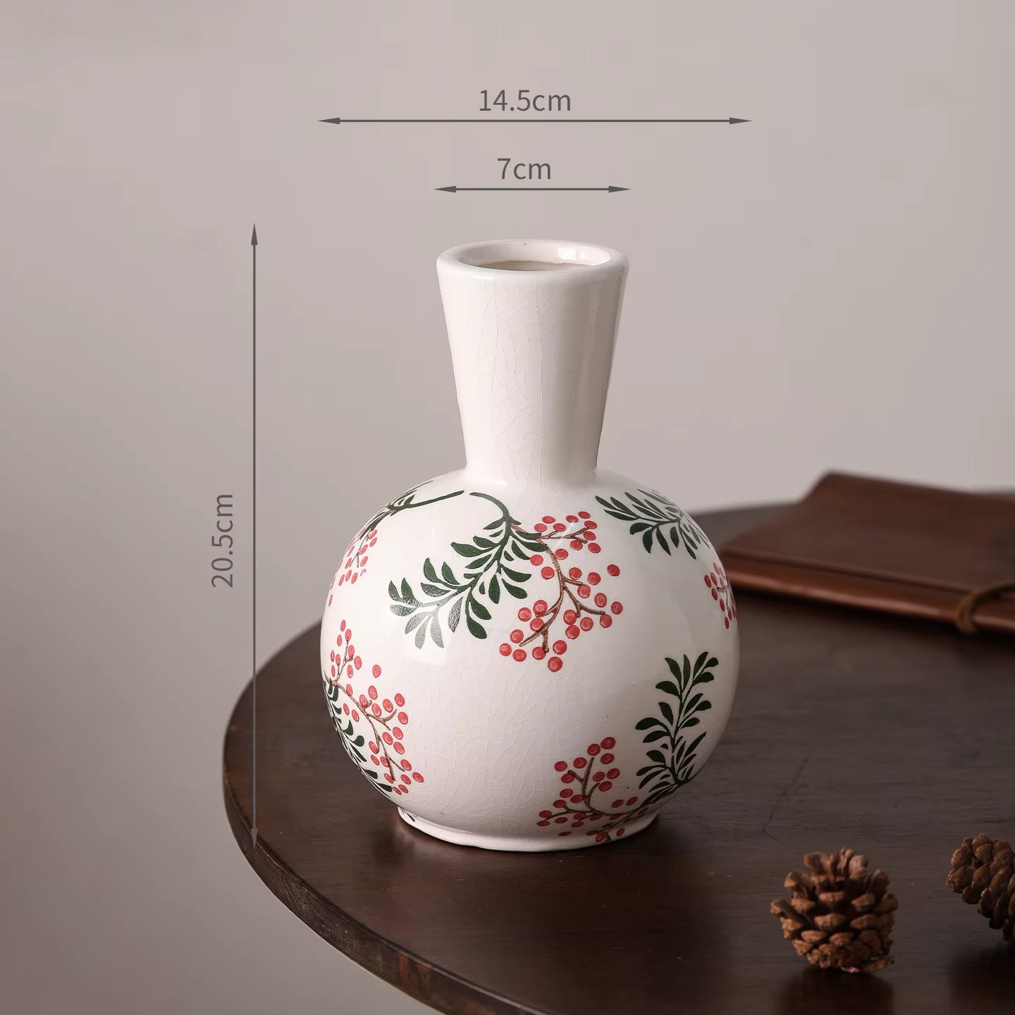 White vase with floral patterns on a wooden surface, with measurements indicated.