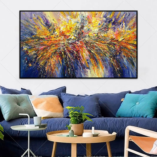 Colorful abstract painting above a blue sofa with decorative pillows in a living room setting.