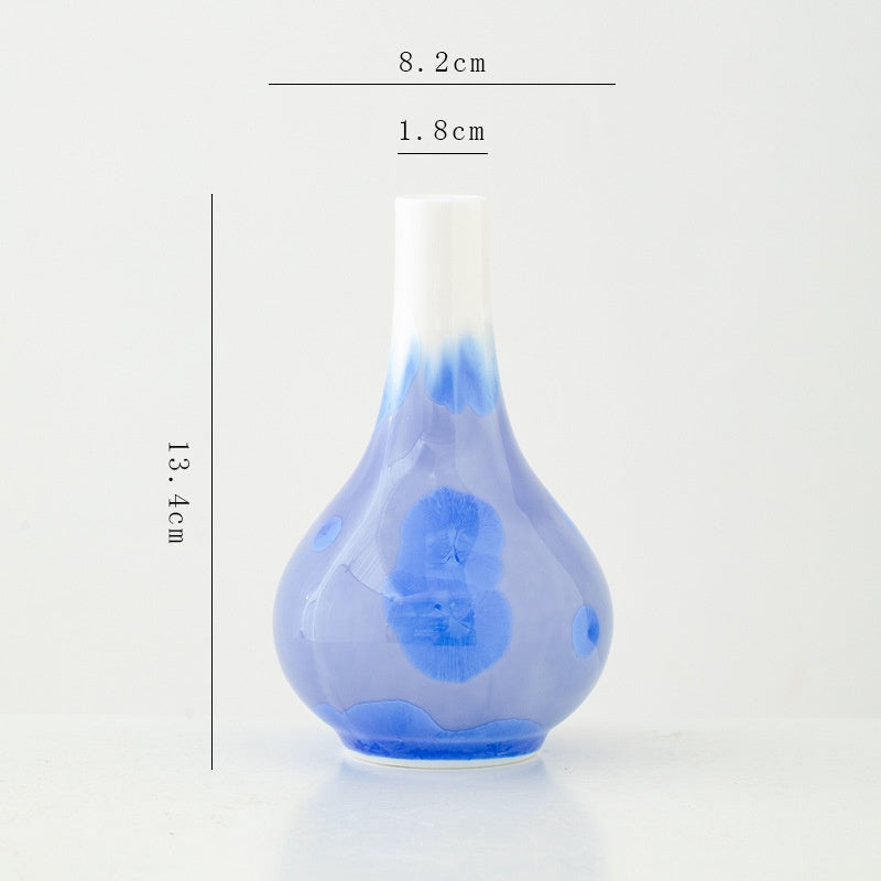 Blue glass vase with measurements on a white background
