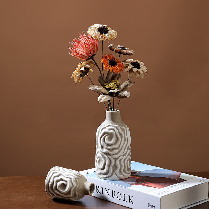 Decorative vase with flowers on a book against a brown background