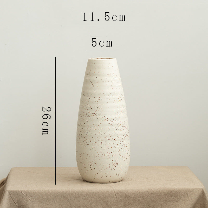 White textured vase on a beige surface with measurements indicated.