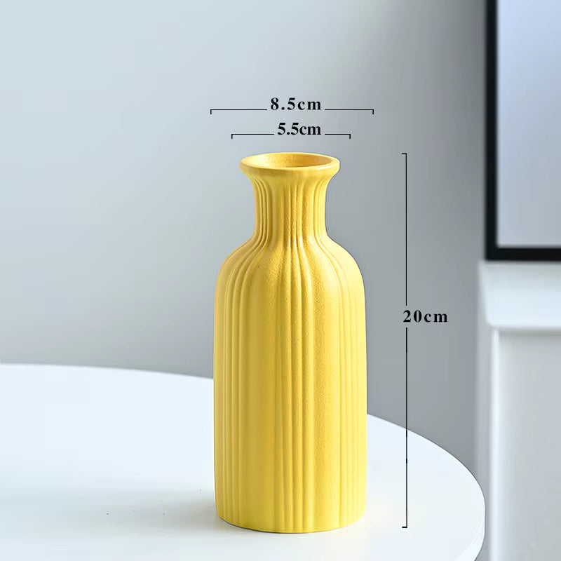 Yellow vase with measurements on a white surface and light gray background