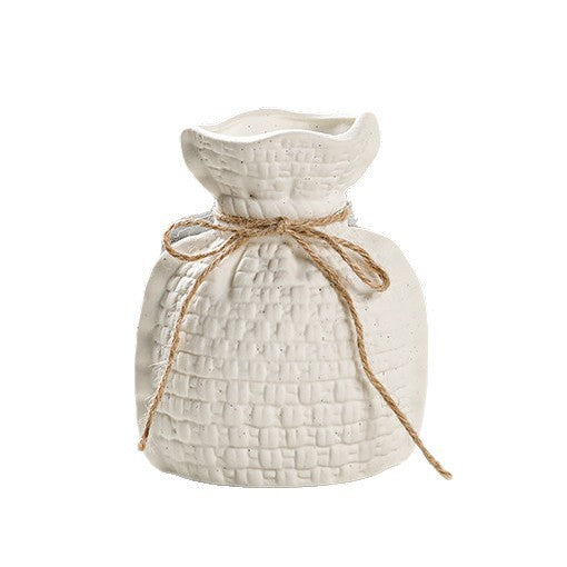 White textured vase with a string bow on a white background
