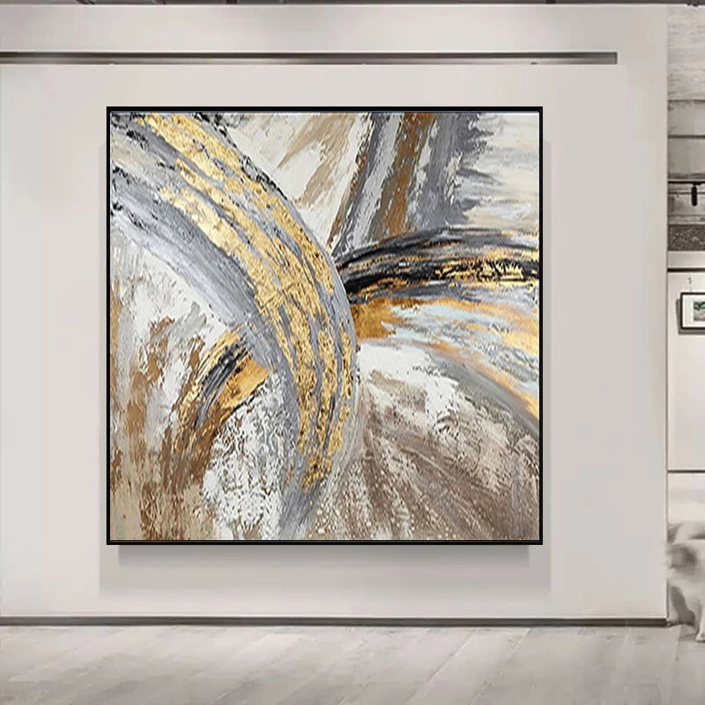 Abstract art piece with gold and gray tones on a white wall.