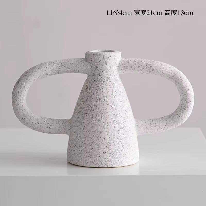 Speckled gray ceramic vase with two handles on a light gray background