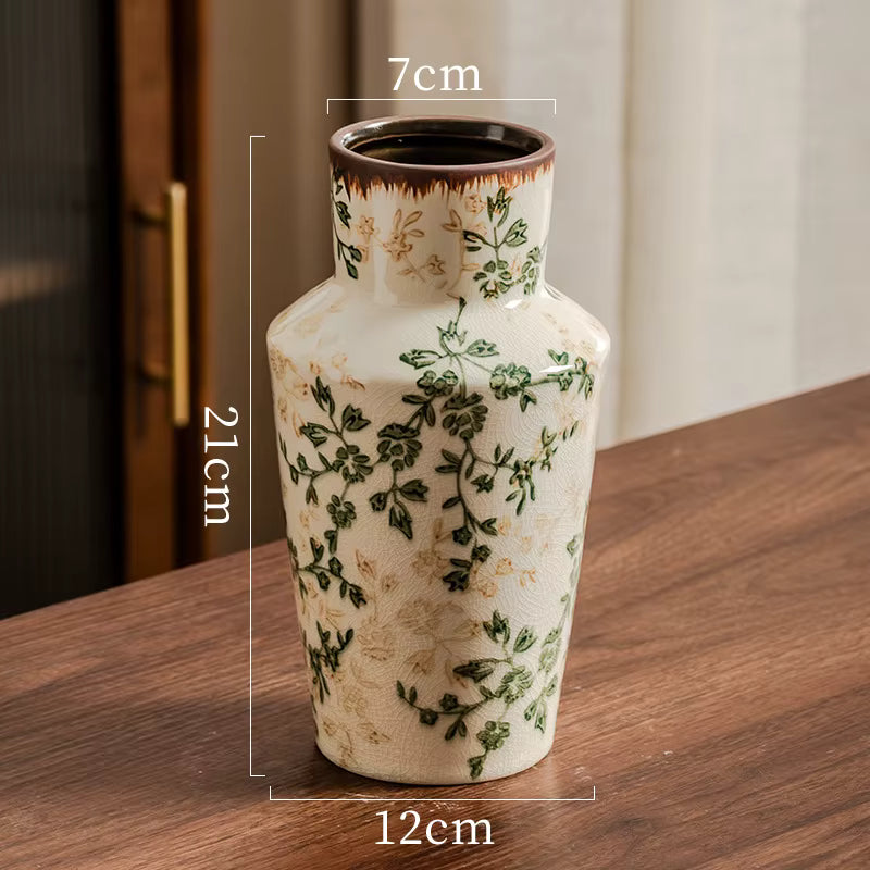 Ceramic vase with floral patterns on a wooden surface, showing measurements.