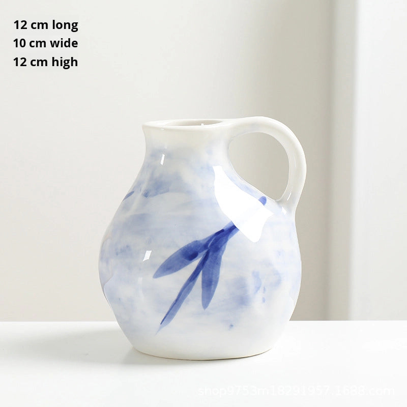 White ceramic pitcher with blue floral design on a white background
