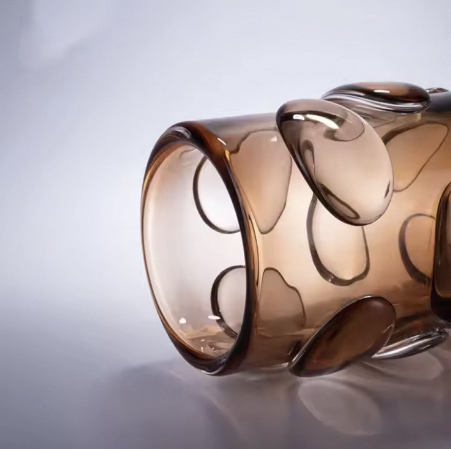 Brown glass vase with wavy design on a light gray background