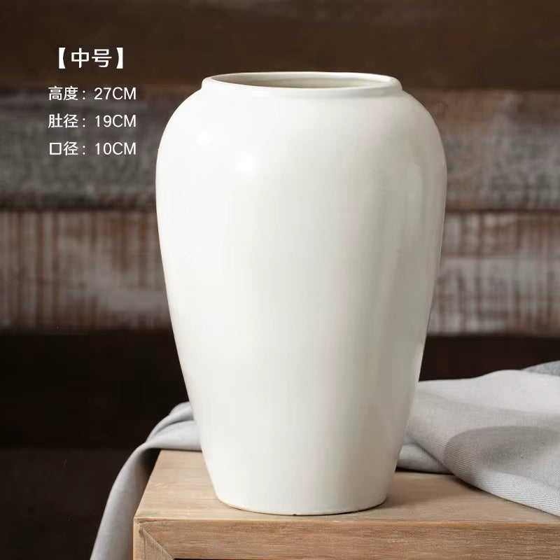 White ceramic vase on a wooden surface with a blurred background