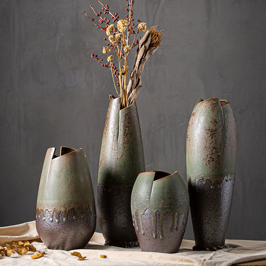Set of four ceramic vases with rustic finishes on a textured surface.