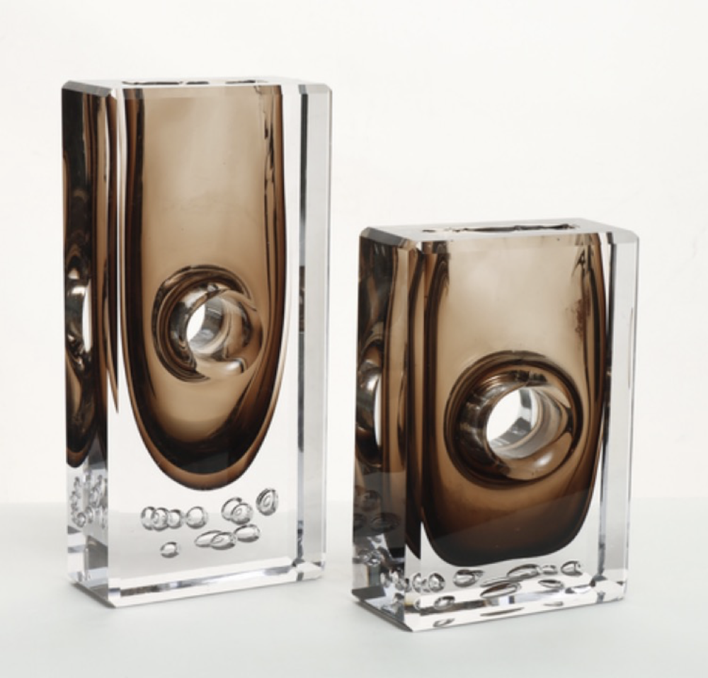 Two glass vases with a metallic brown top and clear base on a white background
