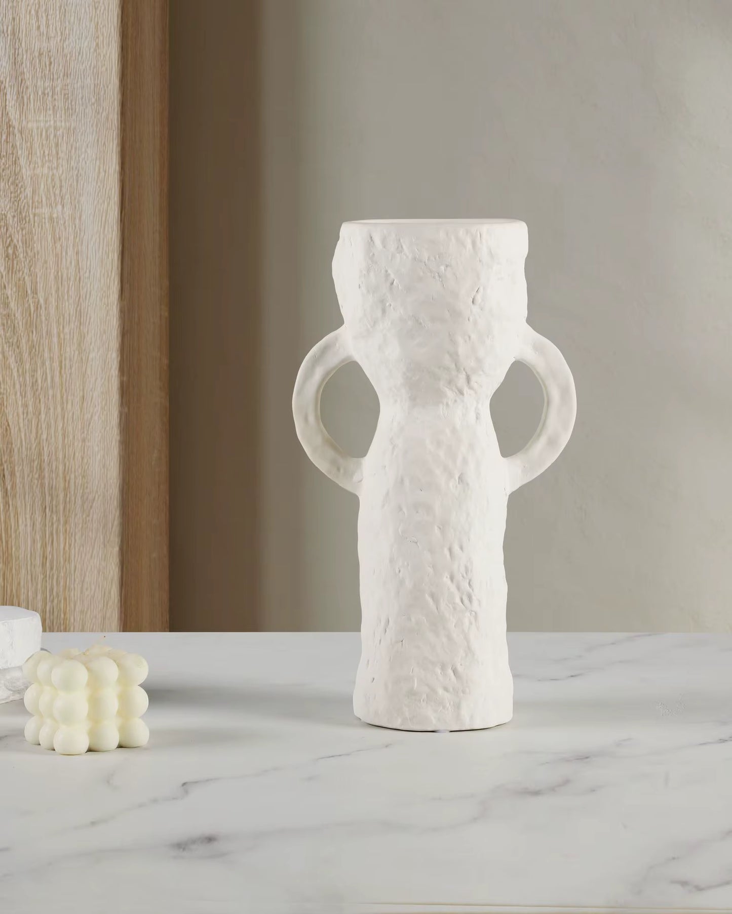 White textured vase with handles on a marble surface