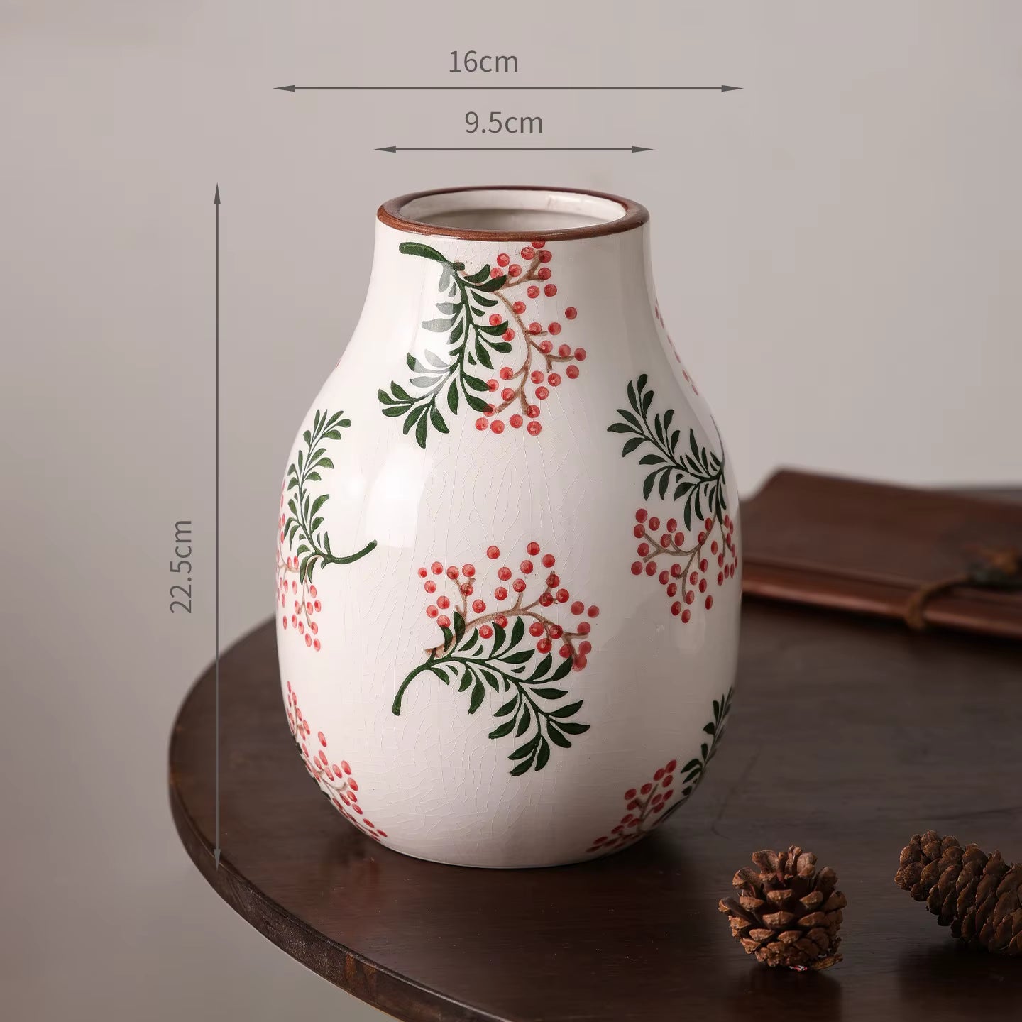 Decorative vase with floral patterns and measurements on a wooden surface