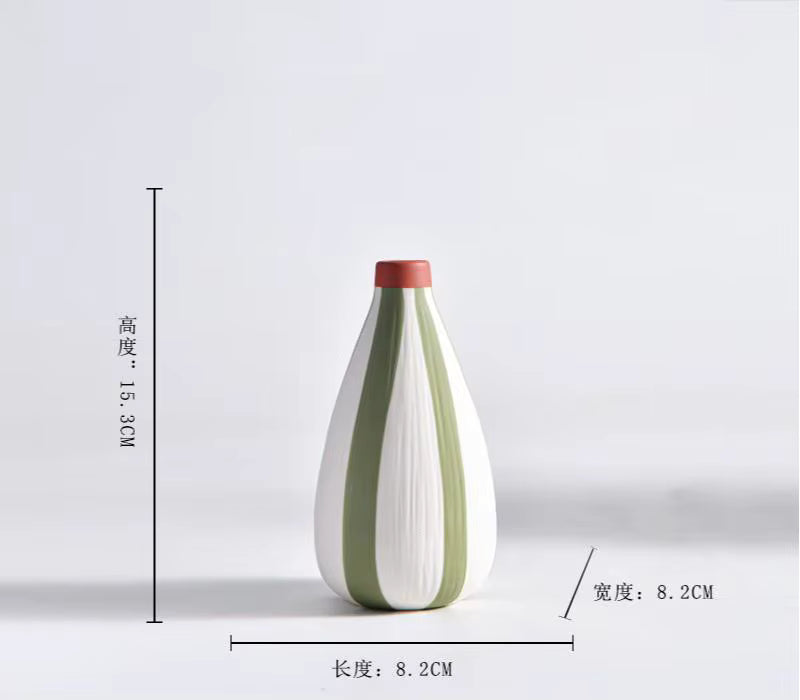 White vase with green stripes and red top on a light gray background
