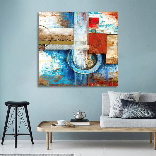 Abstract painting on a wall above a living room setup with a sofa, coffee table, and stool.