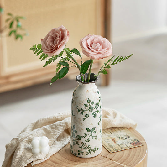 Decorative vase with pink flowers on a wooden surface