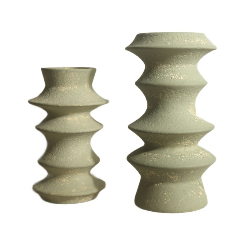 Two textured ceramic candle holders on a white background