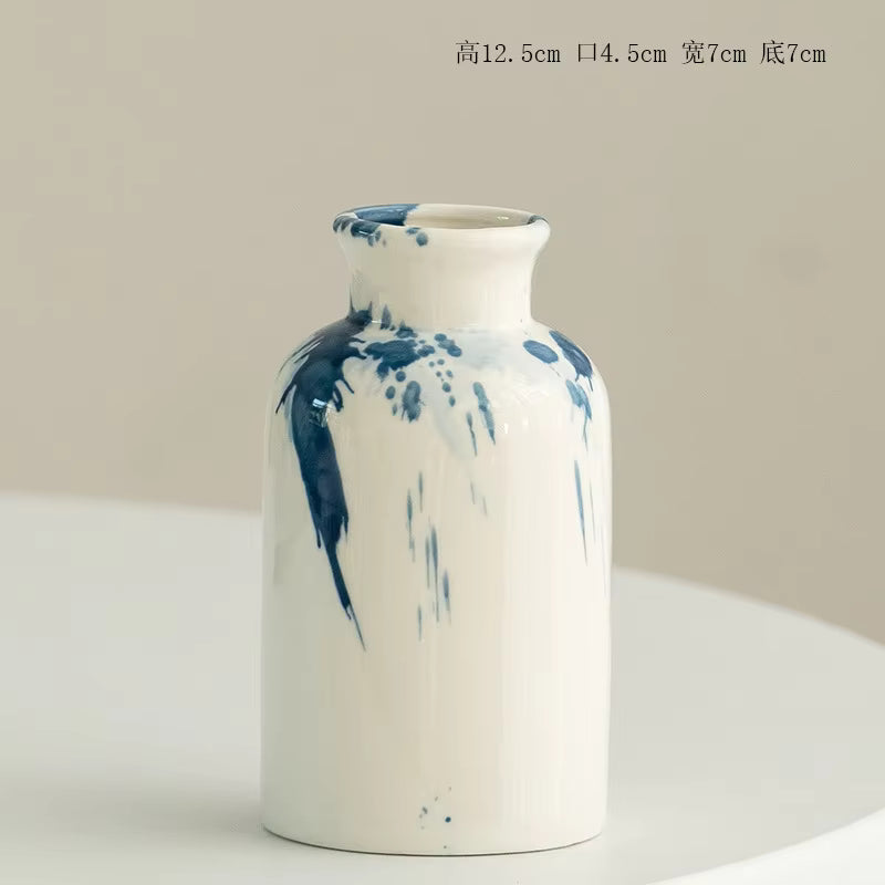 White vase with blue splashes on a beige background