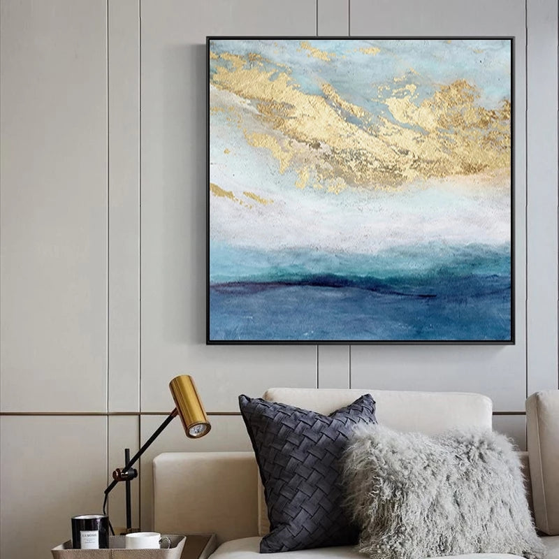 Abstract art piece with gold and blue tones above a sofa in a living room.