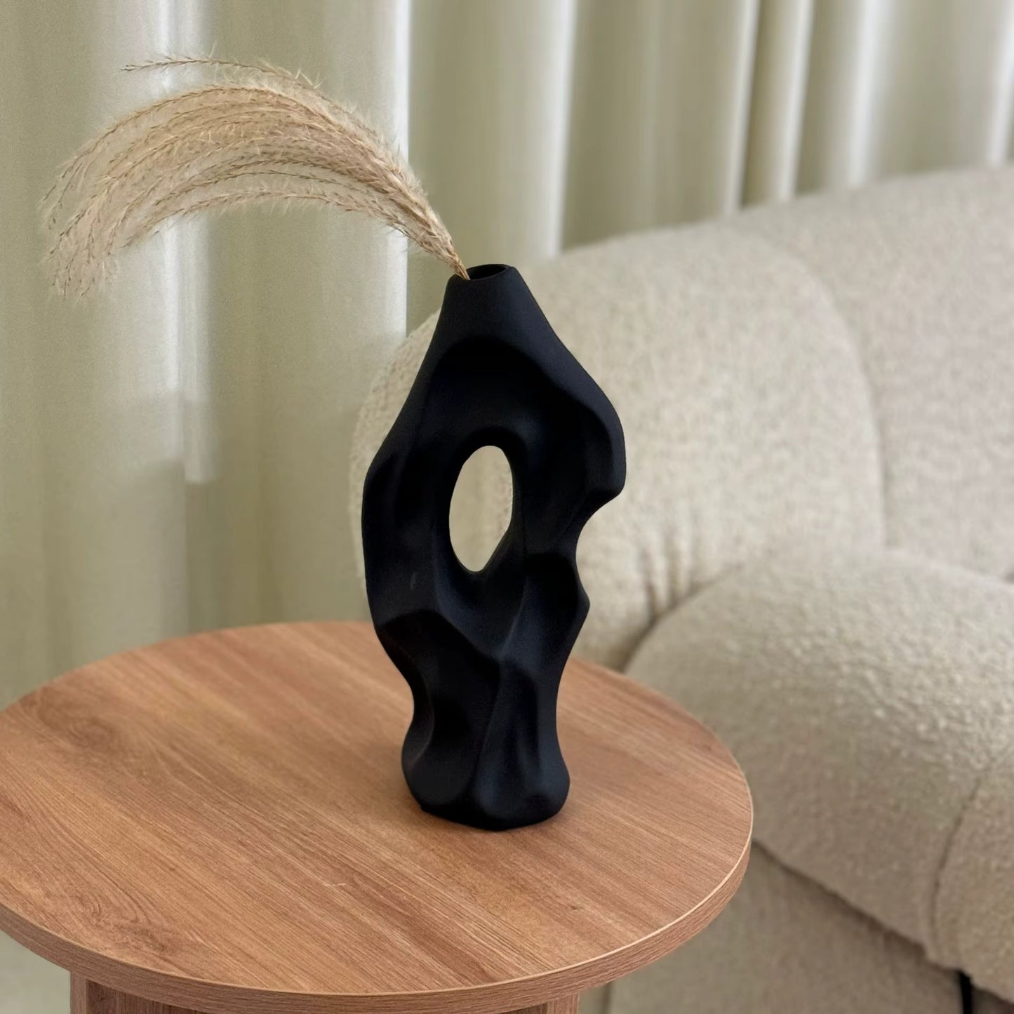 Black abstract vase on a wooden table with a neutral background