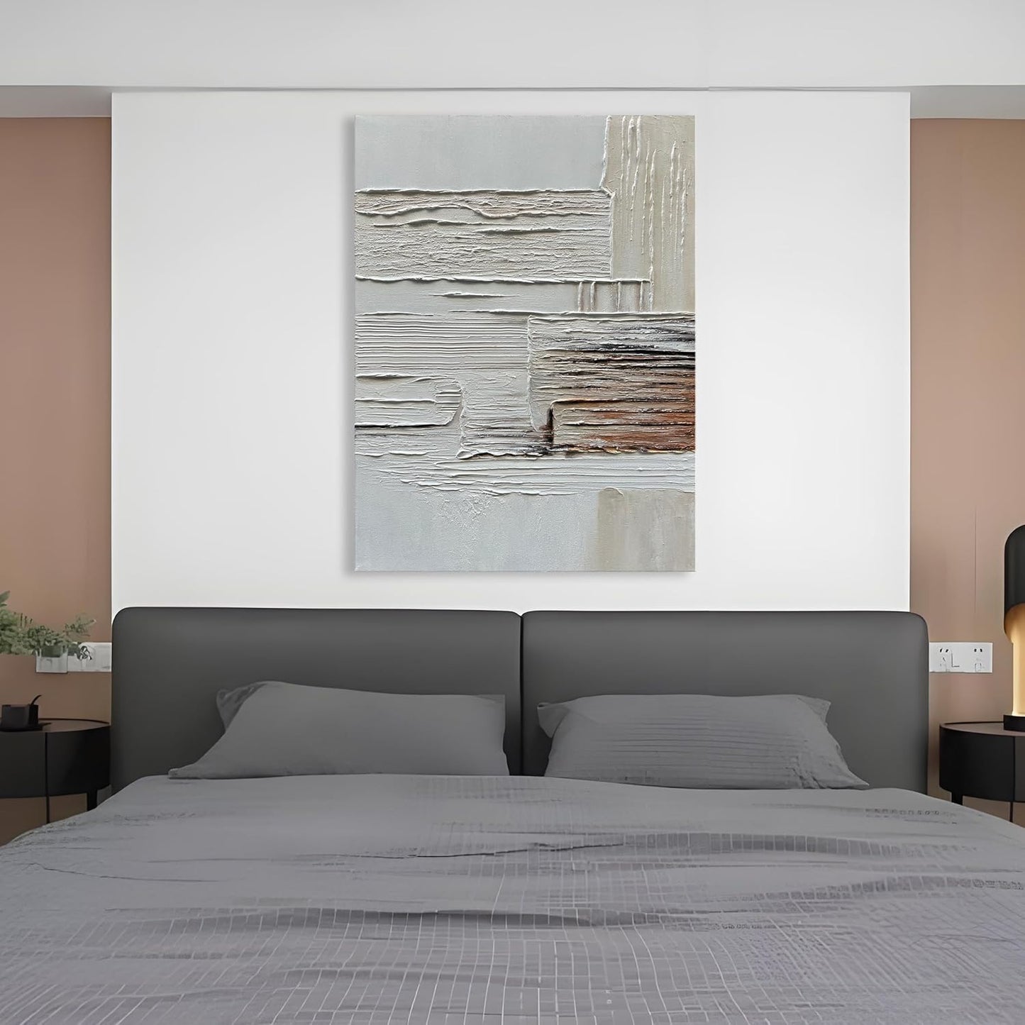 Gray bed with abstract painting on a white wall