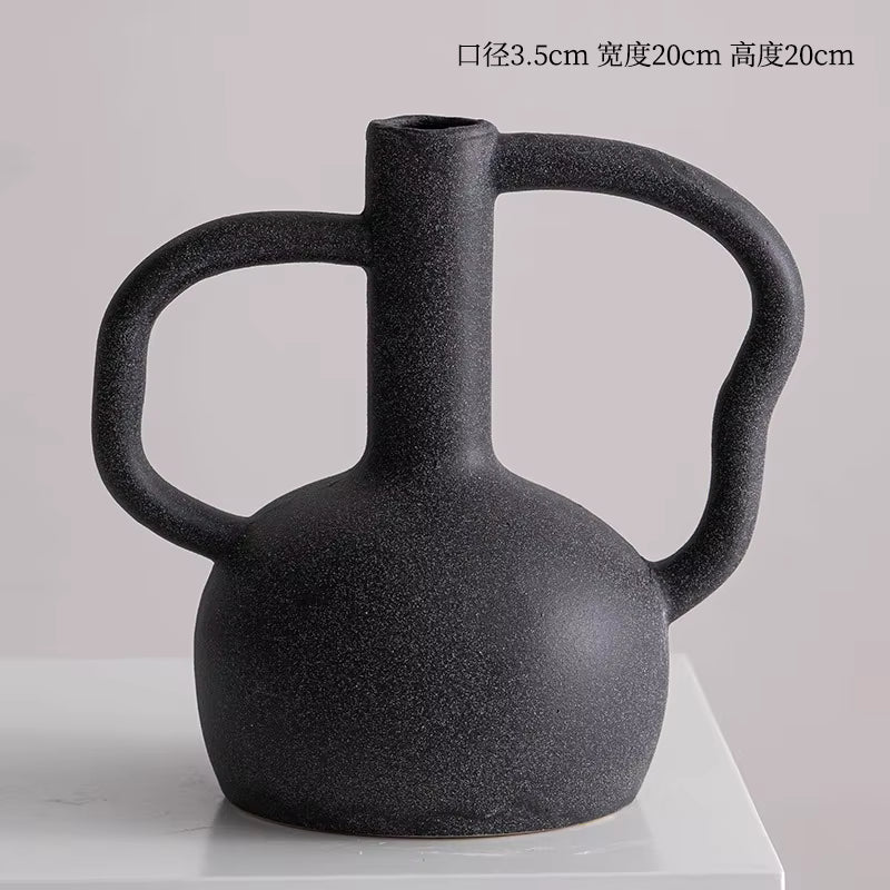 Black ceramic vase with handle on a white background