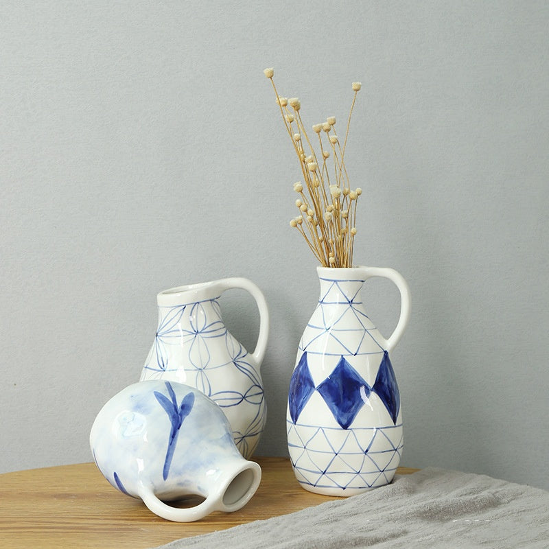 Set of three ceramic vases with blue and white patterns on a wooden surface against a gray background.