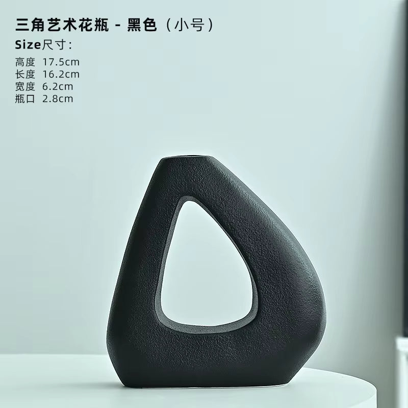 Black artistic vase on a white surface with a light gray background