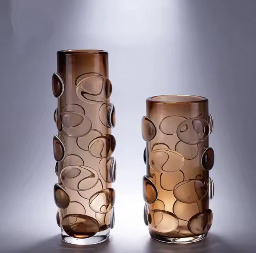Two brown glass vases with circular patterns on a gray background