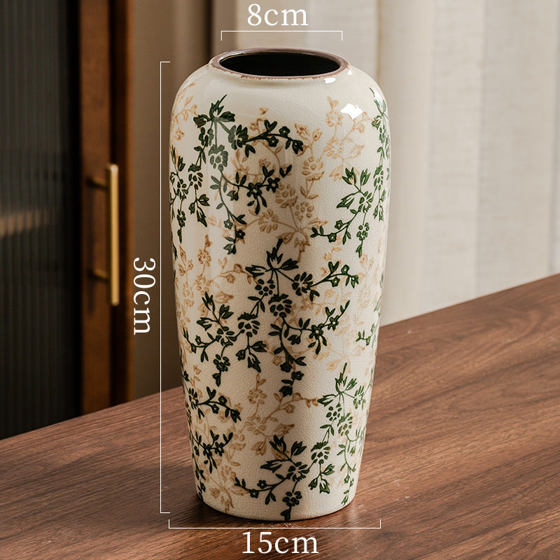 Decorative vase with floral patterns on a wooden surface, showing dimensions.