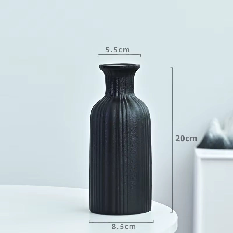 Black ribbed vase with dimensions on a light gray background