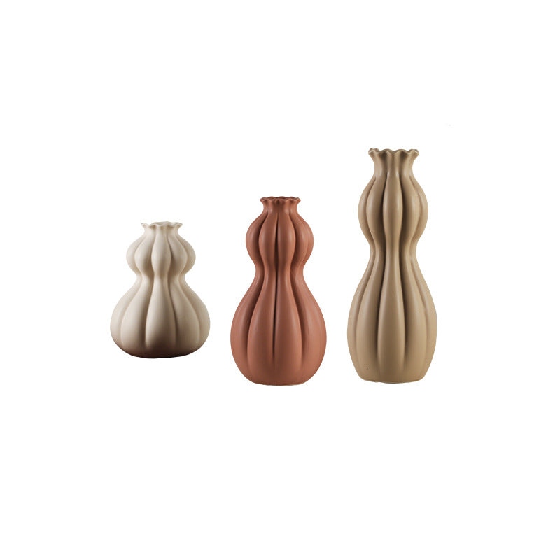 Three ceramic vases in different colors on a white background