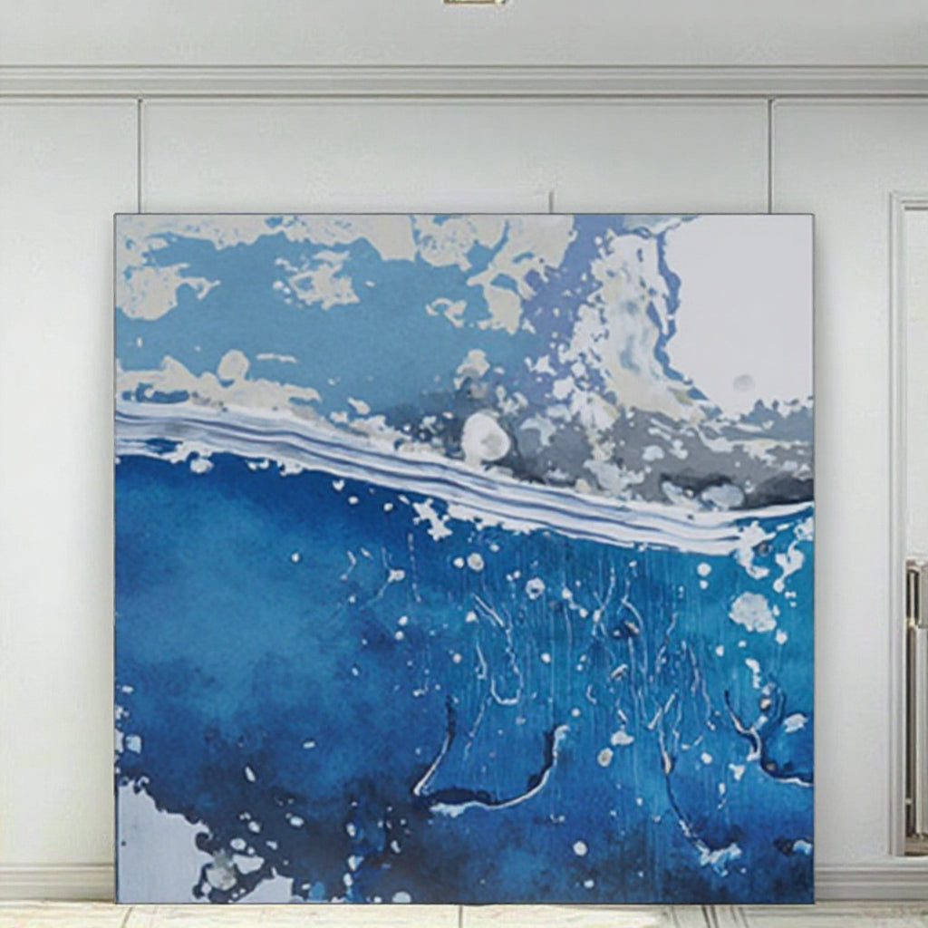 Abstract art piece with blue, white, and gray colors on a white wall.