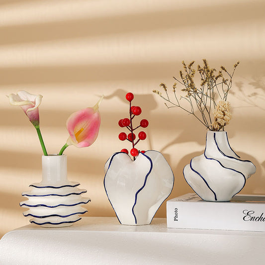 Three decorative vases with floral and berry arrangements on a beige background