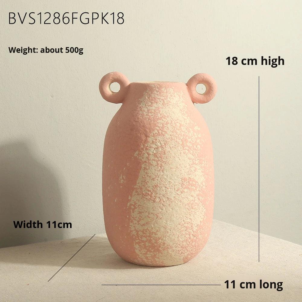 Pink ceramic vase with handles on a light surface, shown with measurements.
