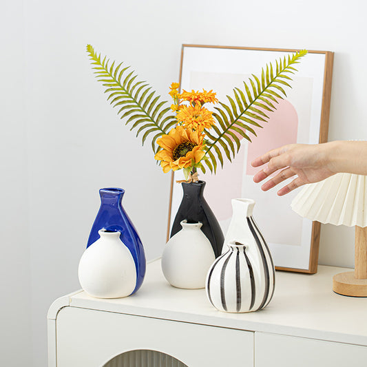 Decorative vases on a table with a hand reaching out