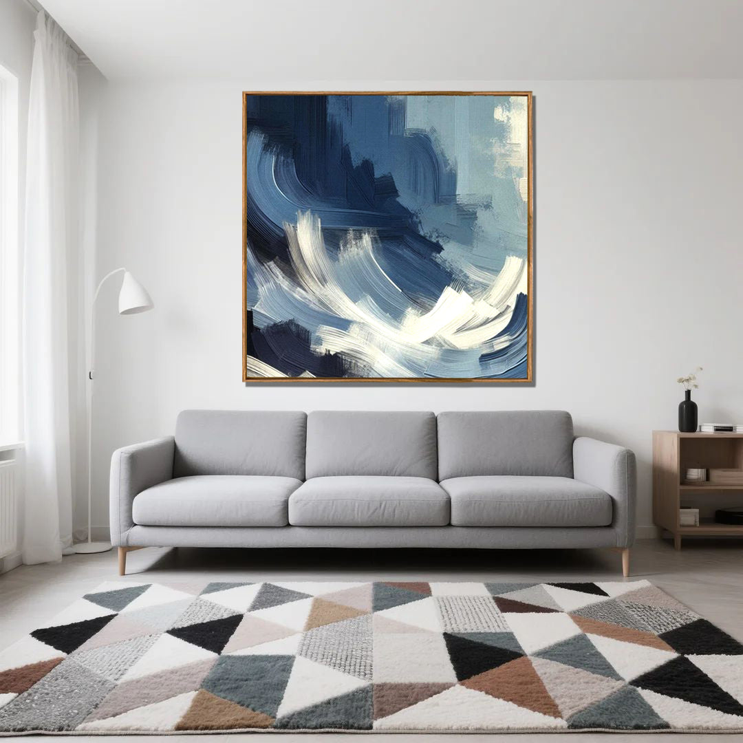 Gray sofa in a living room with a large abstract painting above it and a geometric rug on the floor.
