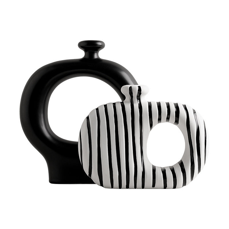 Black and white ceramic vase with striped pattern on a white background
