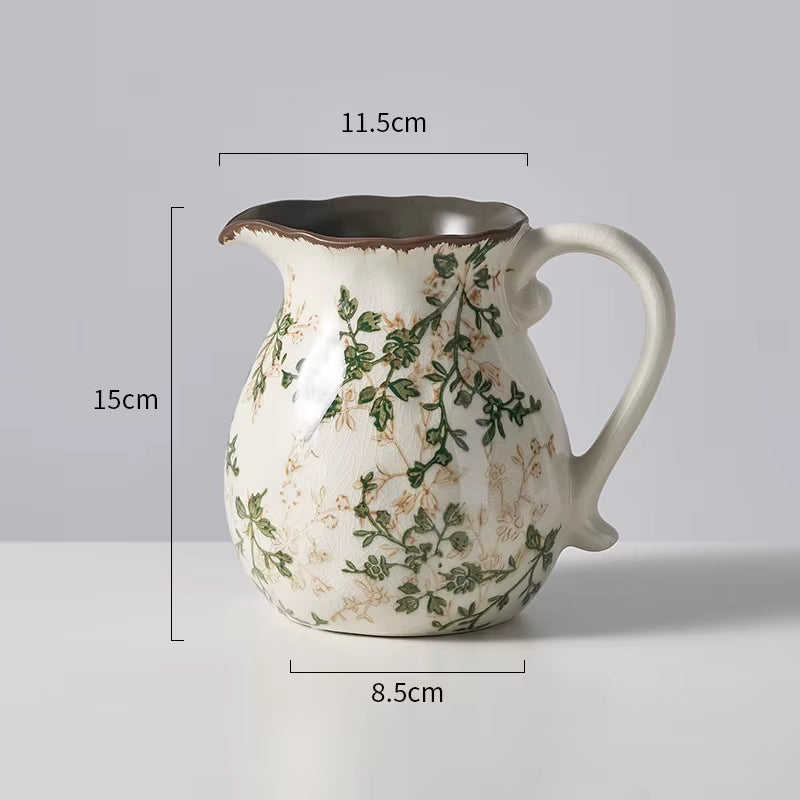 Ceramic pitcher with floral design and measurements on a gray background