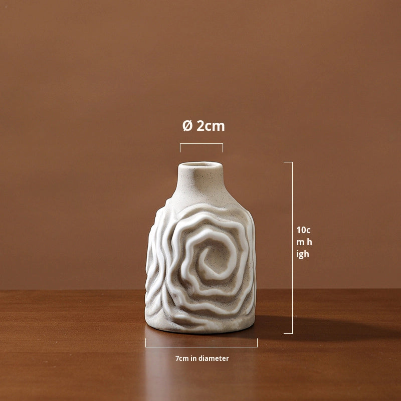 Small ceramic vase with textured design on a wooden surface and brown background