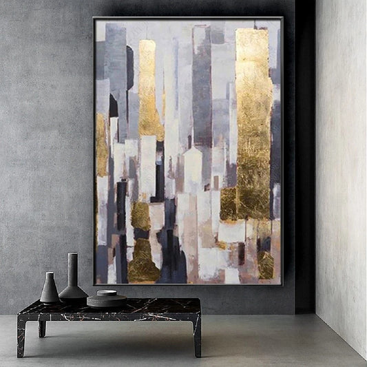Abstract art piece with gold and gray tones in a modern interior setting.