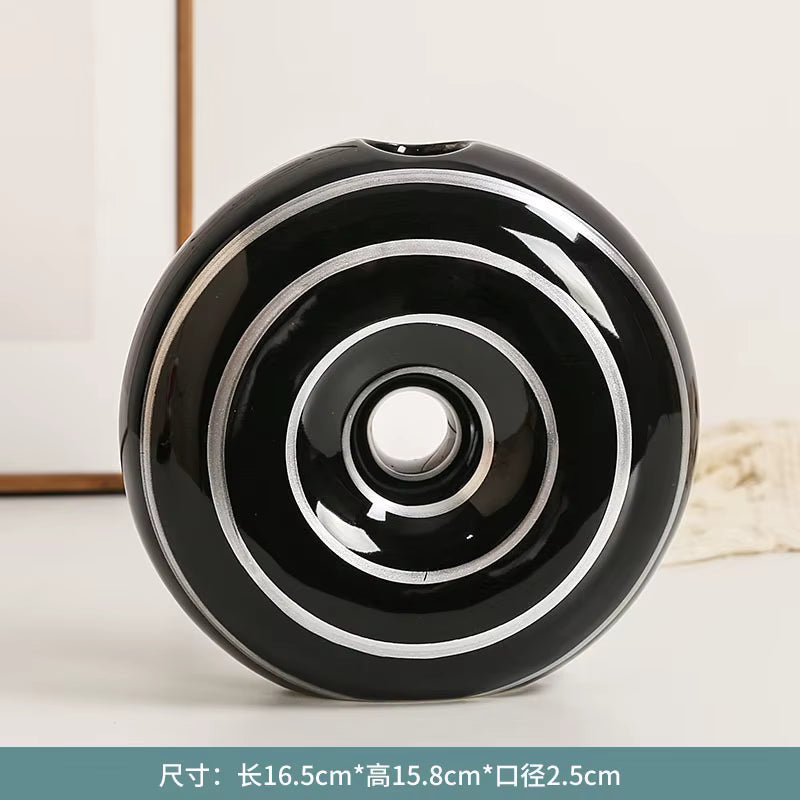 Black and white decorative object with concentric circles on a light background
