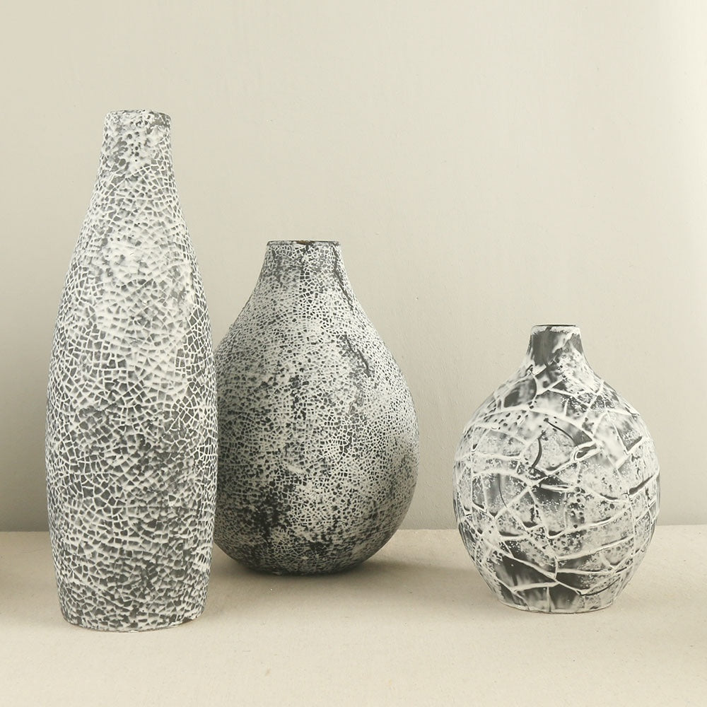 Three textured vases of different sizes on a neutral background