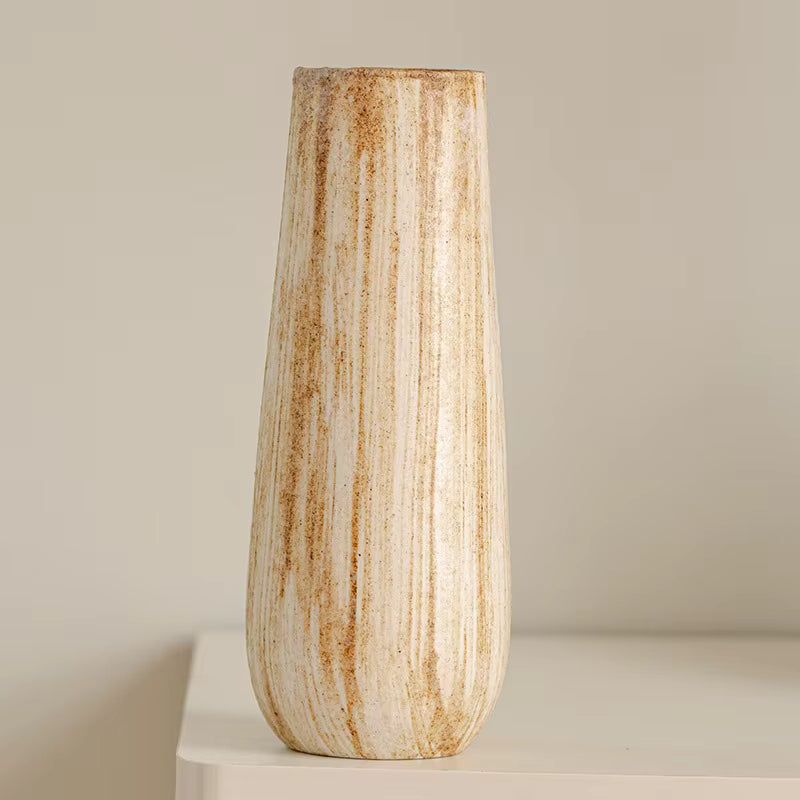 Tall ceramic vase with striped pattern on a neutral background