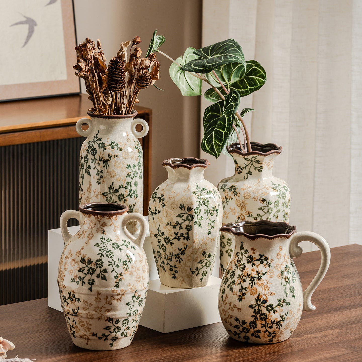 Set of decorative ceramic vases with floral patterns on a wooden surface.