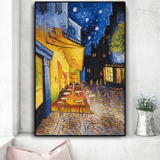 Framed artwork of a street scene with tables and chairs, resembling Van Gogh's style, on a white wall.