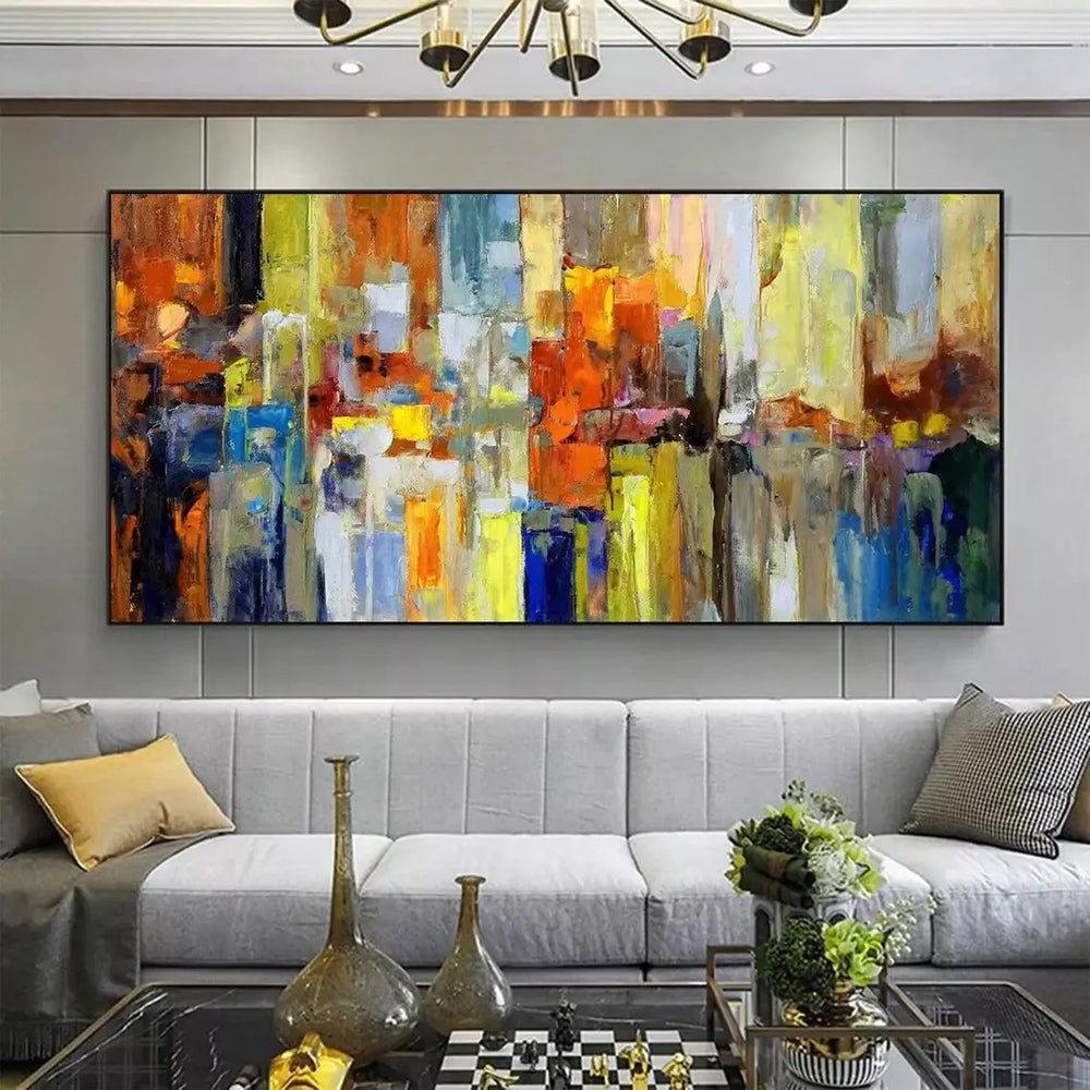 Abstract painting on a wall above a gray sofa in a living room.