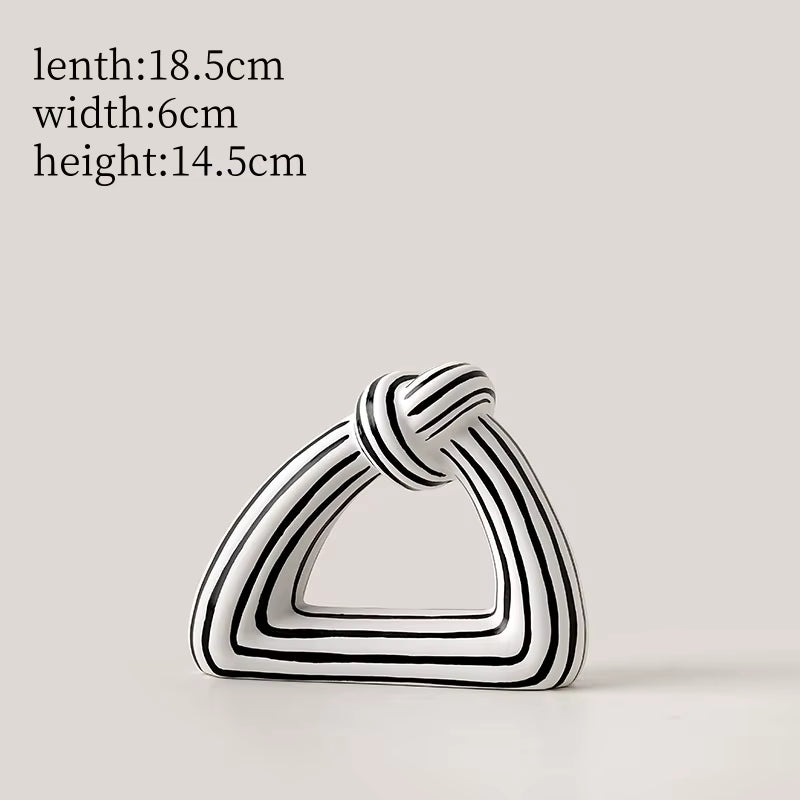 Black and white striped geometric sculpture on a light gray background