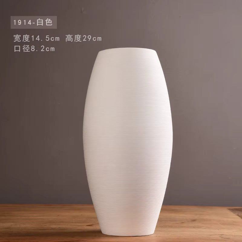 White textured vase on a wooden surface with a gray background