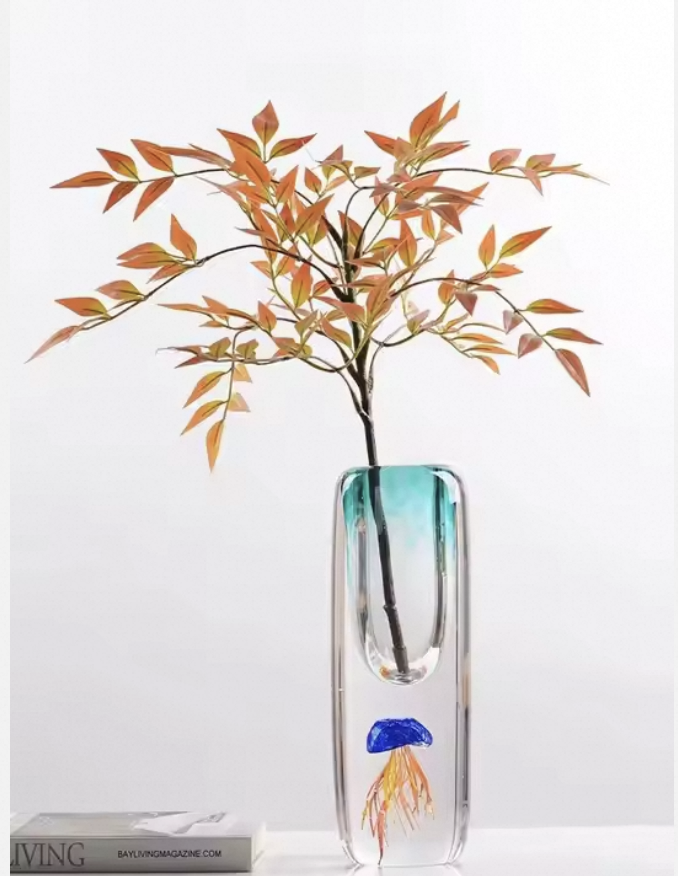 Glass vase with a plant on a white background